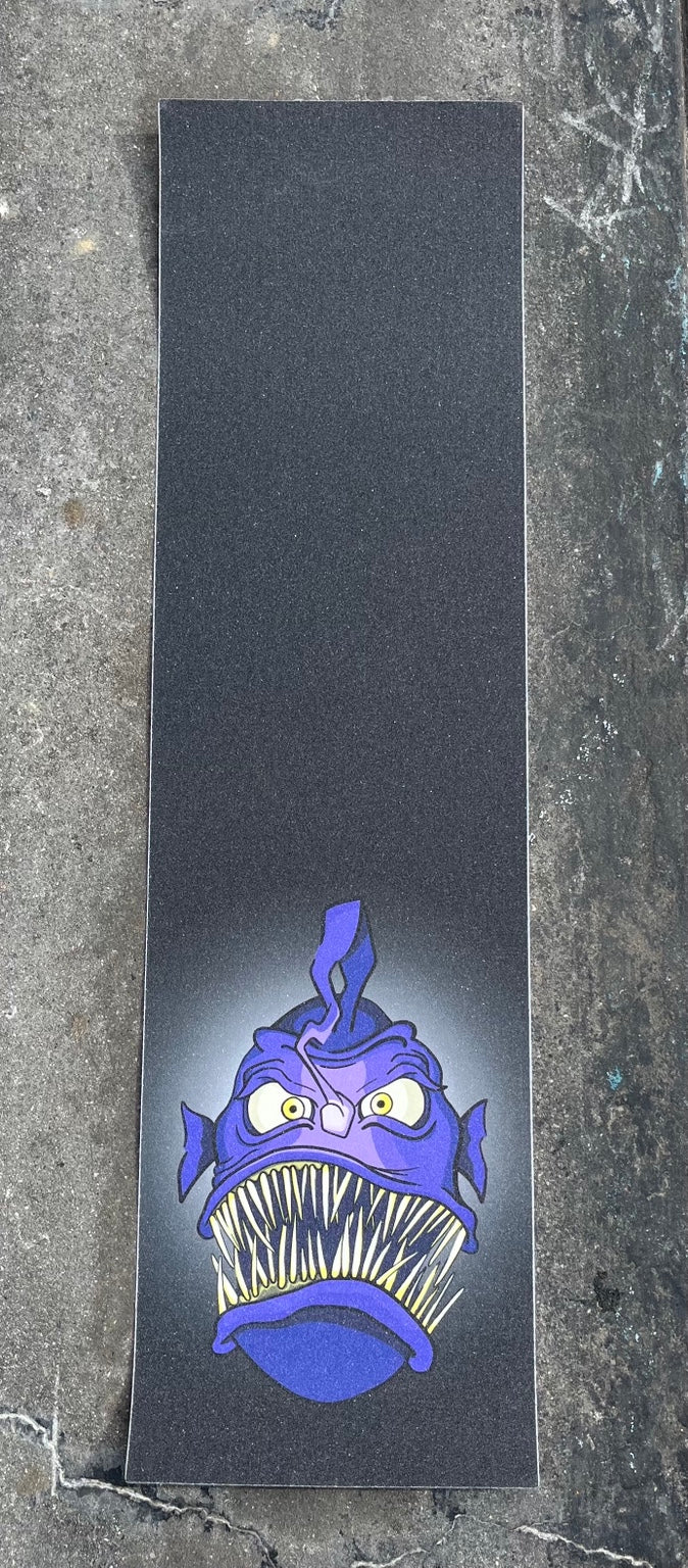Baffled Panda Angler graphic skateboard grip tape photographed on skatepark concrete